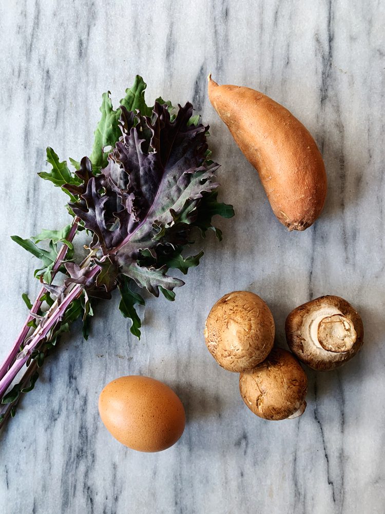 Hearty breakfast hash ingredients: kale, sweet potato, mushrooms, and one egg