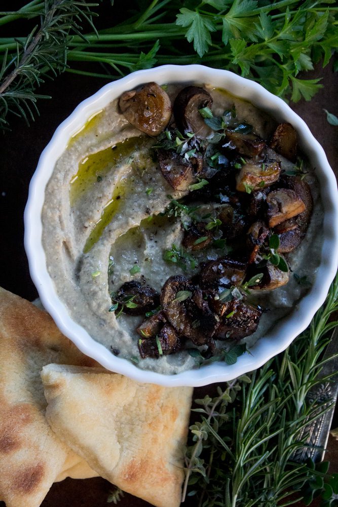 Mushroom Hummus with Thyme + Rosemary plated with parsley, sauteed mushrooms, rosemary and flatbread on the side