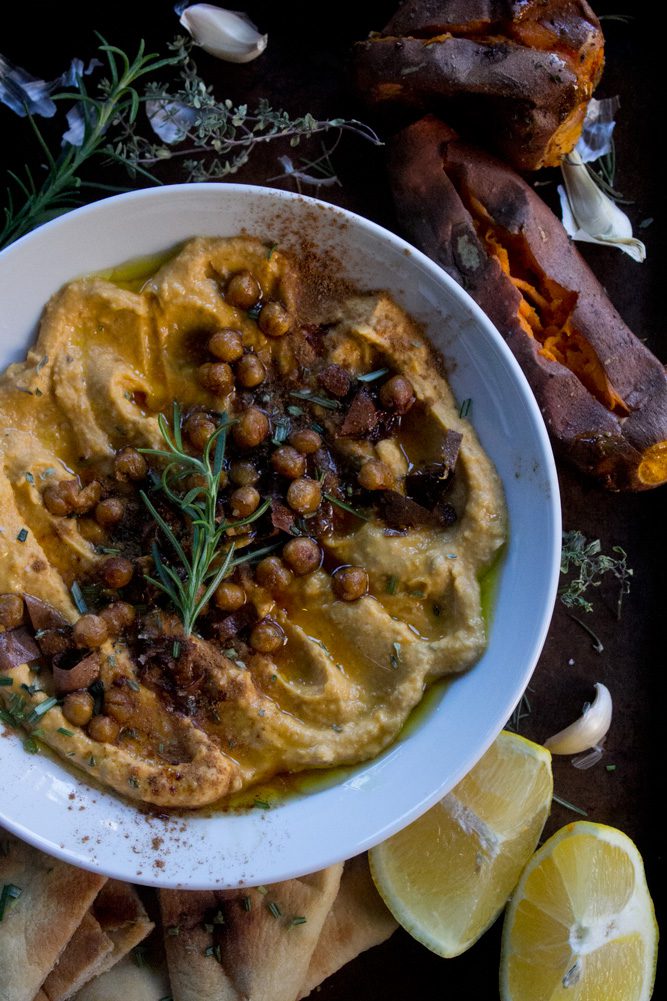 Roasted Sweet Potato Hummus plated with crispy chickpeas, rosemary, and roasted sweet potatoes on the side