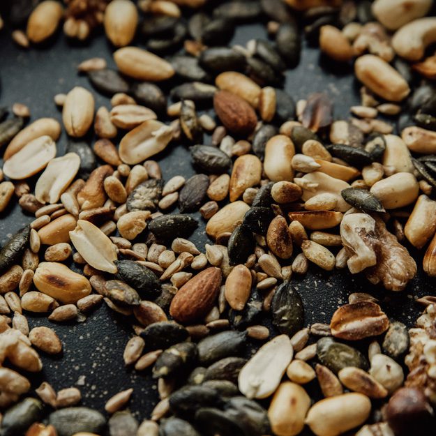 Salad Philosophy: Close up image of seeds + nuts: peanuts, pumpkin seeds, sunflower seeds
