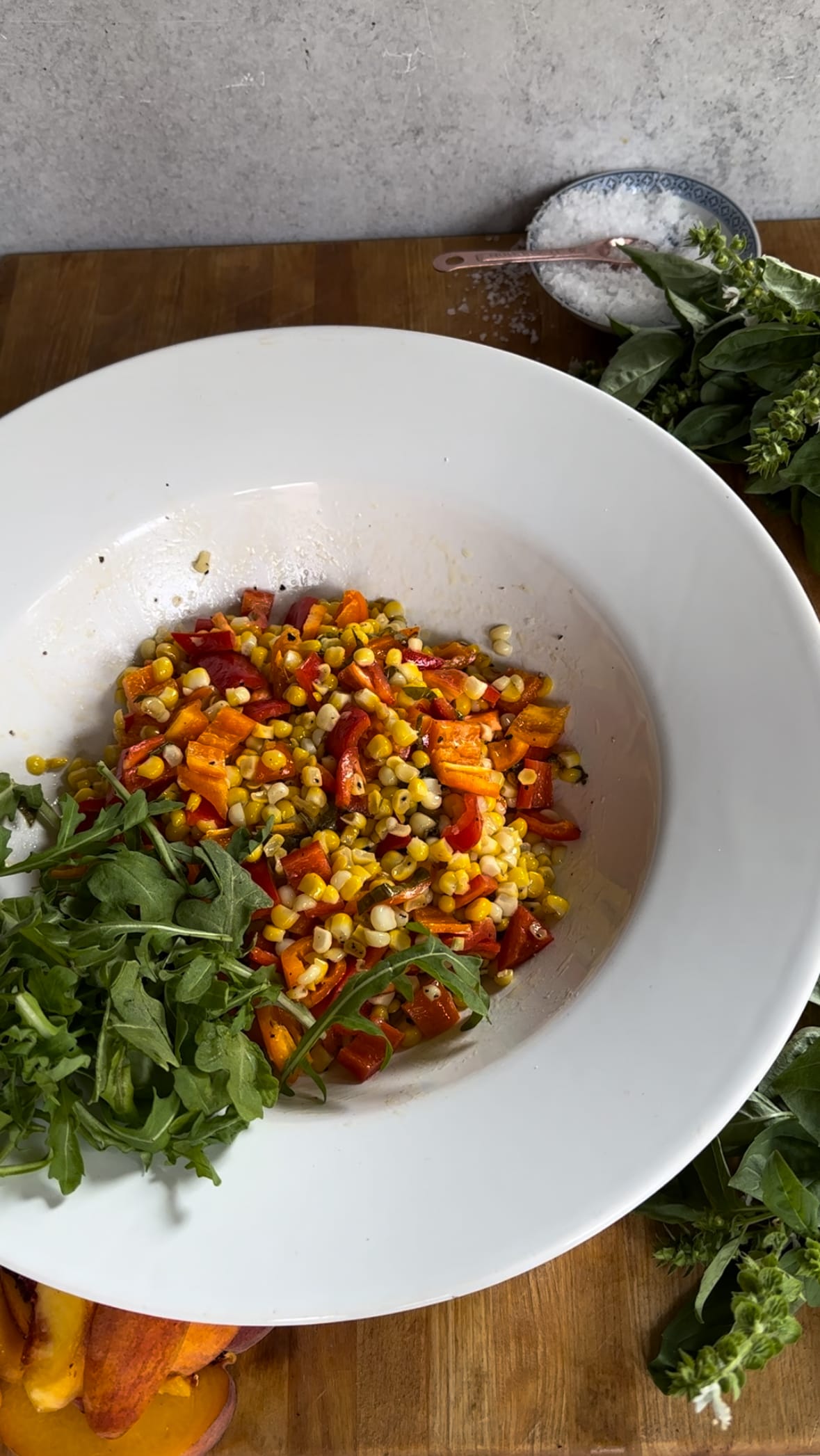 Plating up Summer corn, sweet pepper, and peach salad with arugula