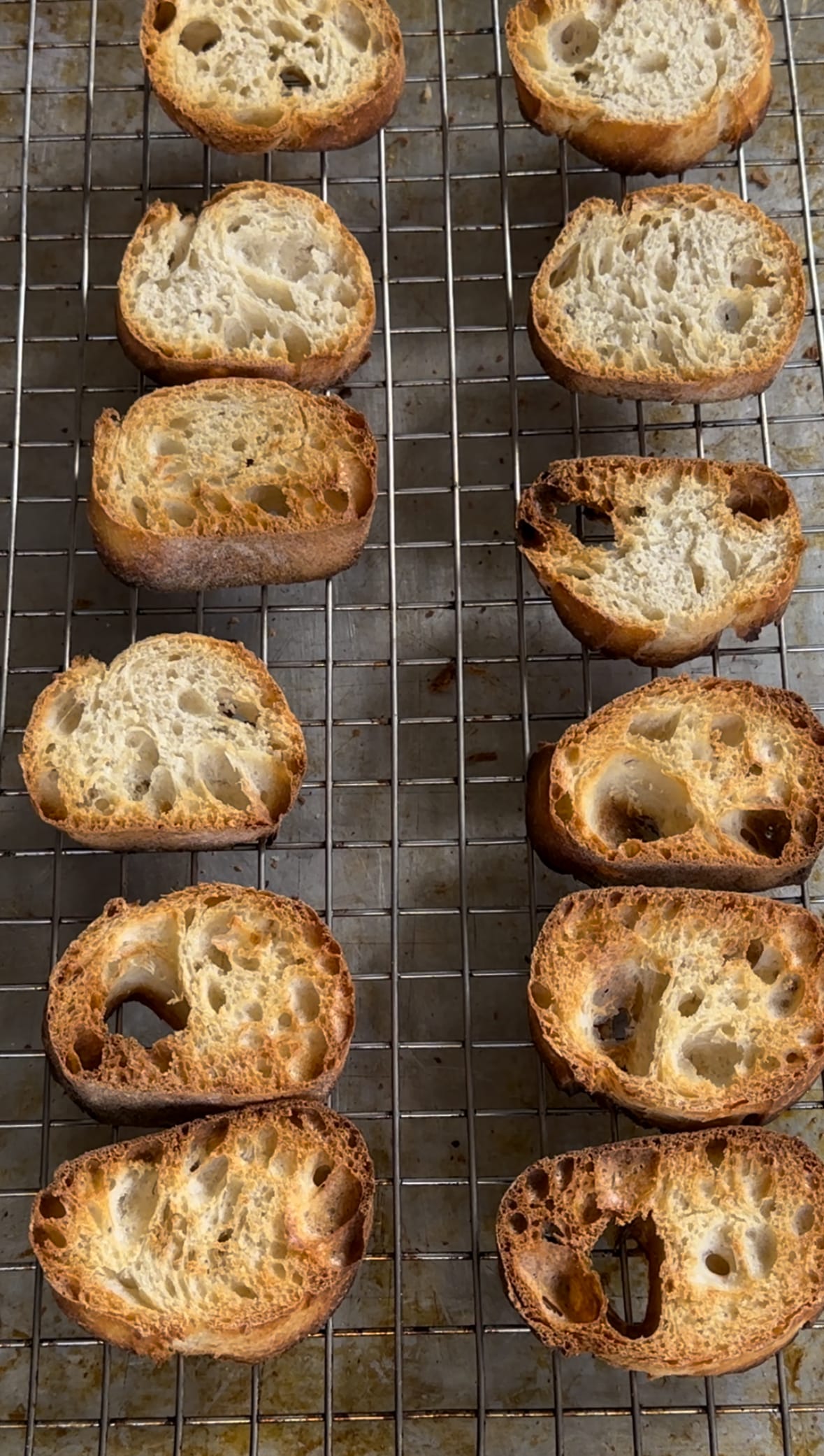 Toasted French baguette on a baking sheet for Summer Tomato Crostini