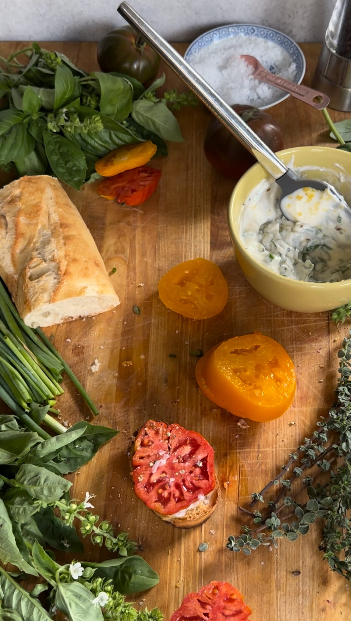 Summer Tomato Crostini - all the ingredients on a cutting board to make summer tomato crostini: French bread, summer tomatoes, herby mayo